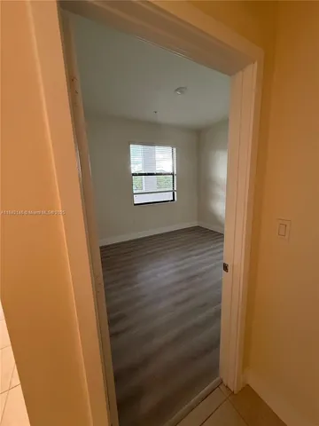 a view of hallway with window and hardwood floor