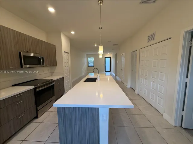 a kitchen with a sink a stove top oven and cabinets