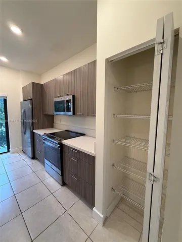 a large kitchen with a refrigerator and a sink