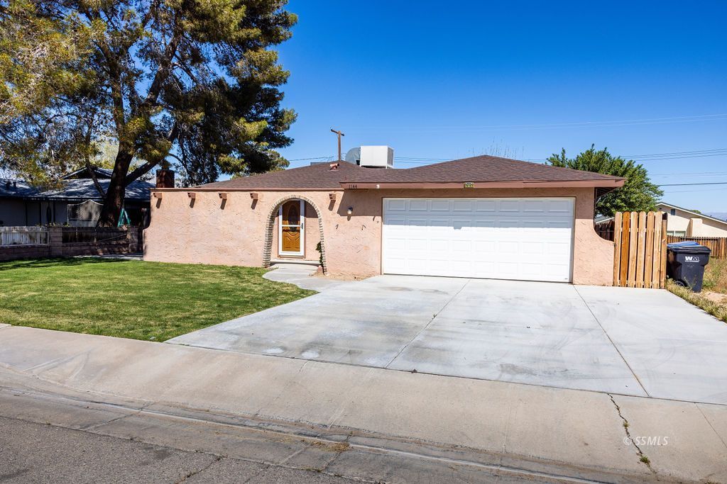 1144 West Benson Avenue Ridgecrest, CA 93555 - Photo 4 of 32 a front view of a house with a yard and garage