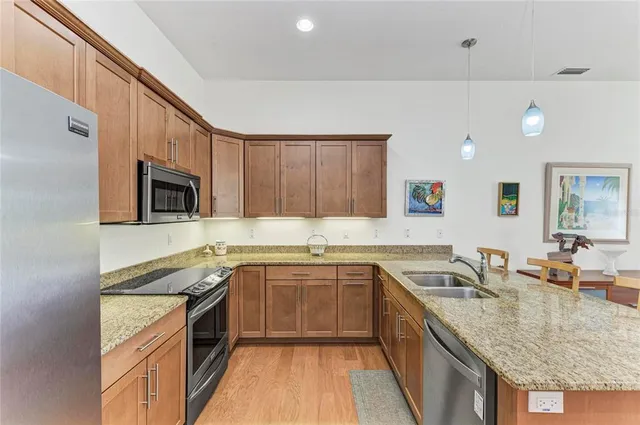a kitchen with stainless steel appliances granite countertop a sink stove and refrigerator