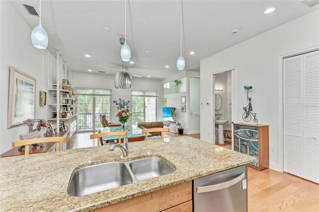 a kitchen with a sink a center island a counter top space appliances and cabinets