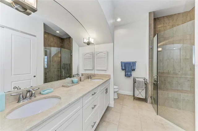 a spacious bathroom with a granite countertop sink mirror and shower