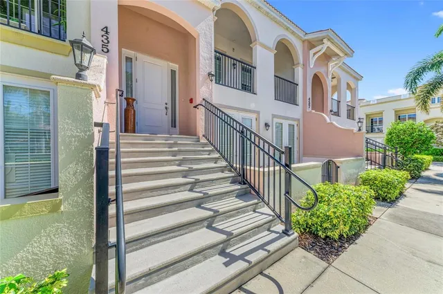 a view of a brick house with many windows next to a yard