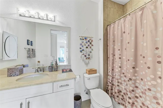 a bathroom with a granite countertop sink mirror vanity and toilet