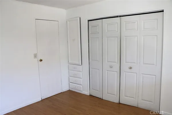 a view of a closet area with hardwood floor