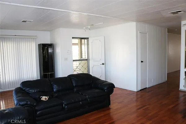 a bedroom with a bed window and wooden floor