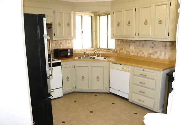 a kitchen with white cabinets and white appliances