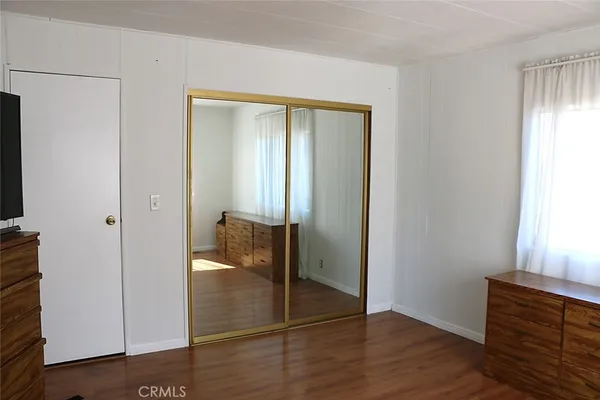 a view of a hallway with wooden floor and closet