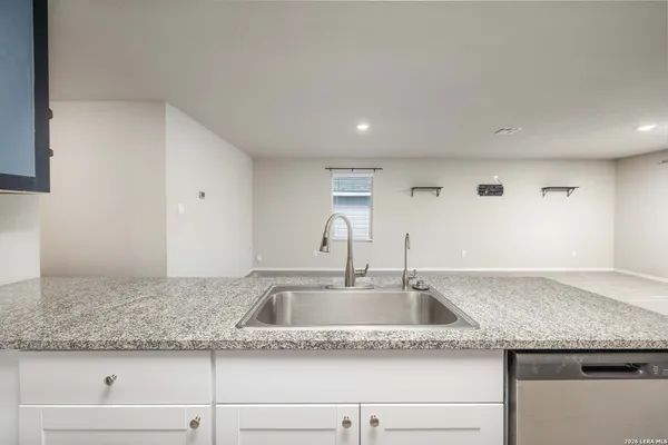 a kitchen with granite countertop a sink and cabinets