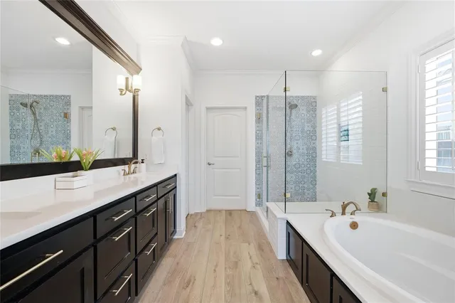 a spacious bathroom with a double vanity sink a large mirror and shower