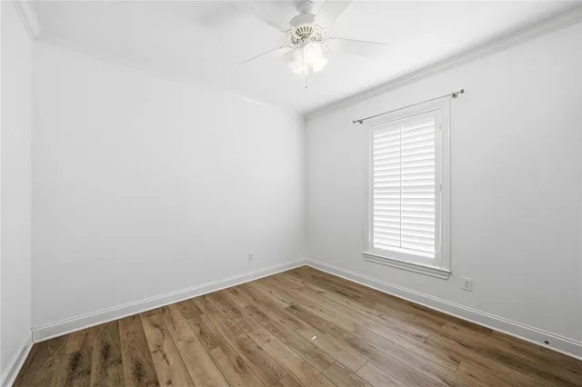 an empty room with a window and a ceiling fan