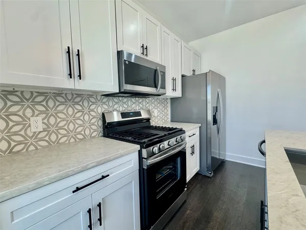 a kitchen with stainless steel appliances granite countertop a stove a refrigerator and a microwave