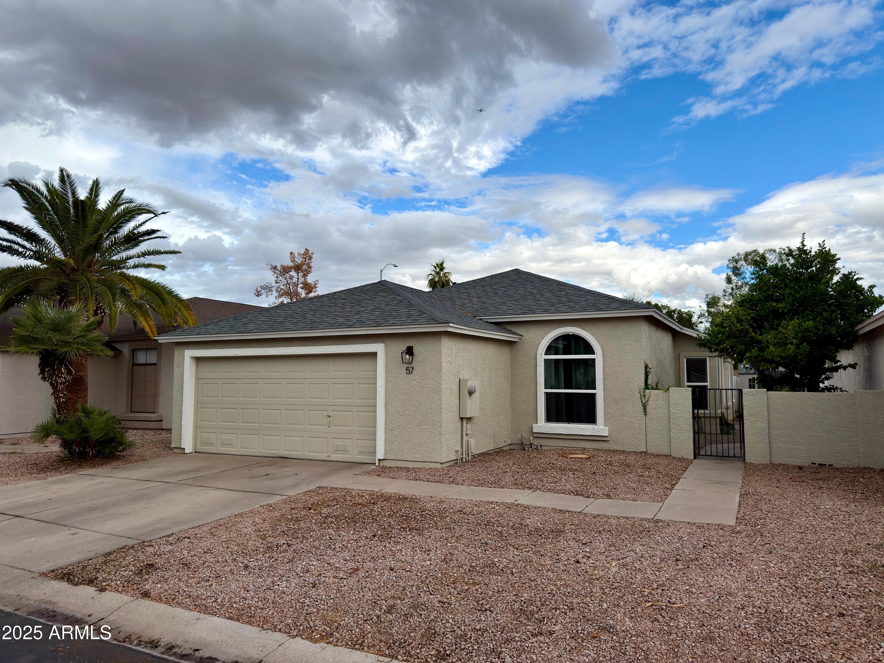 4725 East Brown Road, Unit 57 Mesa, AZ 85205 - Photo 2 of 14 a view of a house with a yard and garage