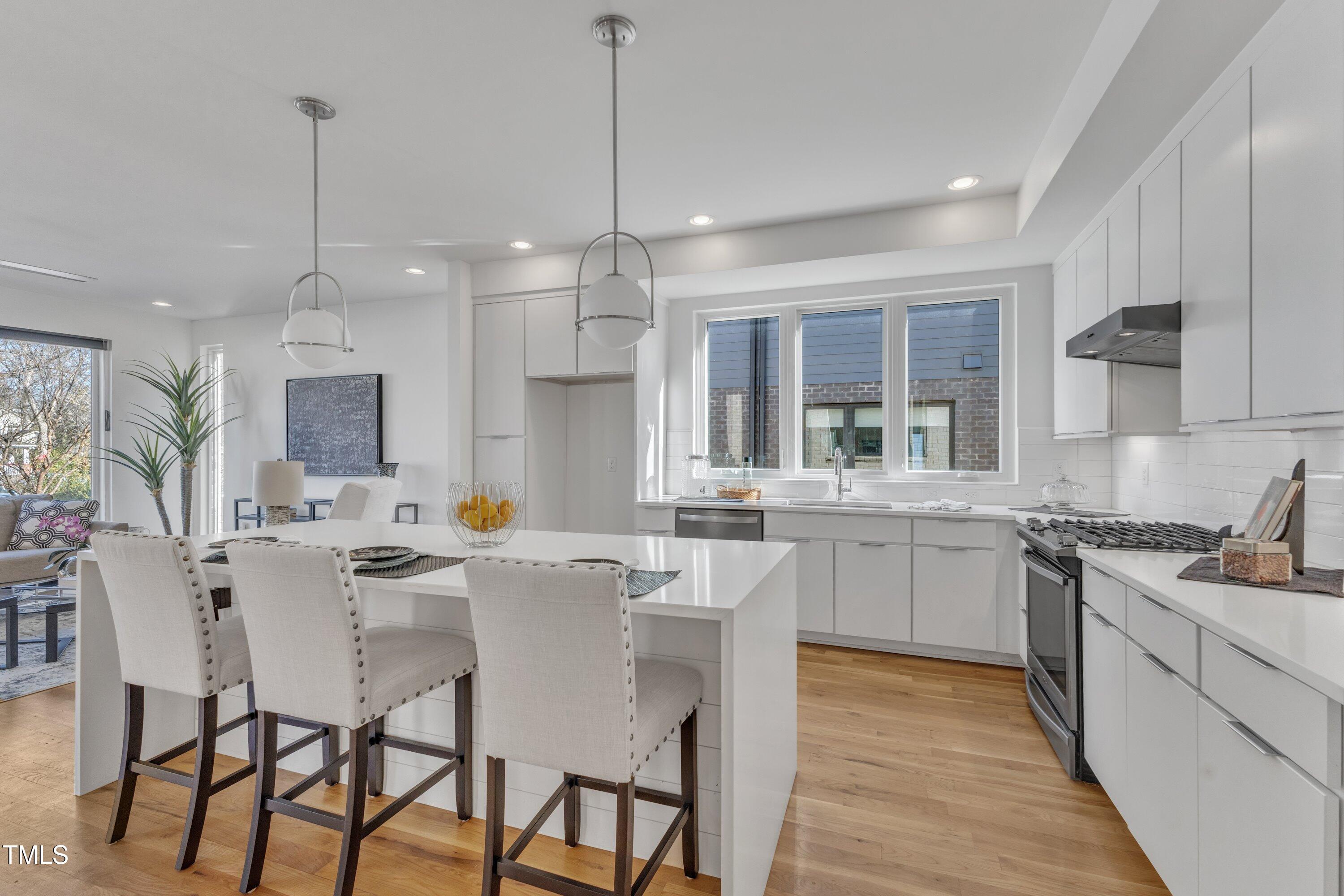 524 East Edenton Street Raleigh, NC 27601 - Photo 12 of 70 a kitchen with stainless steel appliances kitchen island granite countertop a sink a stove a dining table and chairs