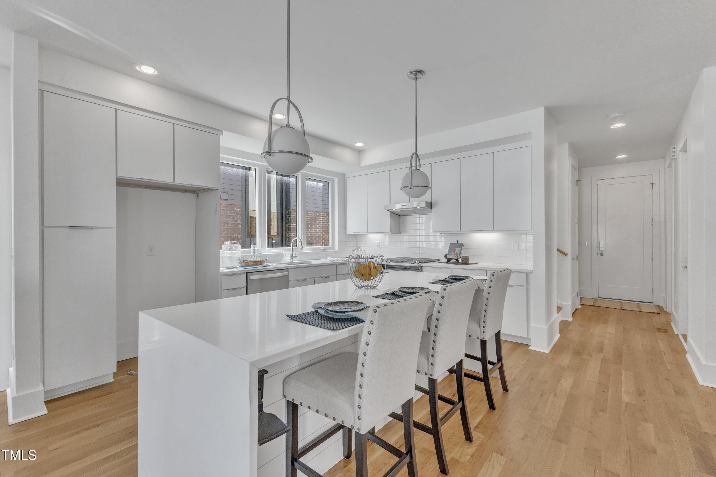 524 East Edenton Street Raleigh, NC 27601 - Photo 18 of 70 a kitchen with stainless steel appliances a dining table chairs stove and white cabinets