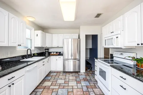 a bathroom with a granite countertop sink a shower and a mirror
