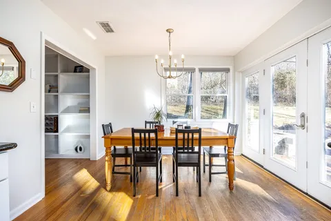a view of backyard with table and chairs under an umbrella