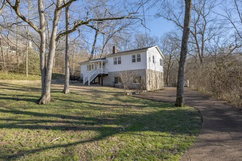 a kitchen with stainless steel appliances granite countertop a stove a refrigerator a dining table and chairs with wooden floor