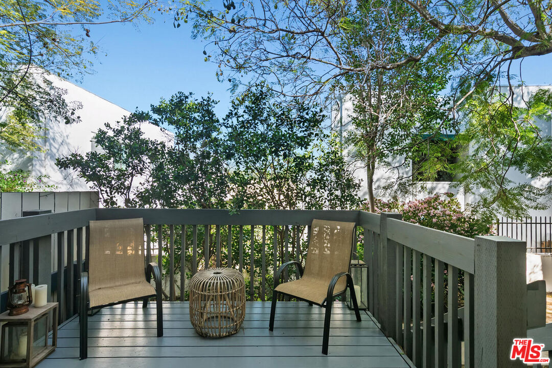 29239 Heathercliff Road, Unit 12 Malibu, CA 90265 - Photo 5 of 32 a deck with table and chairs and wooden floor