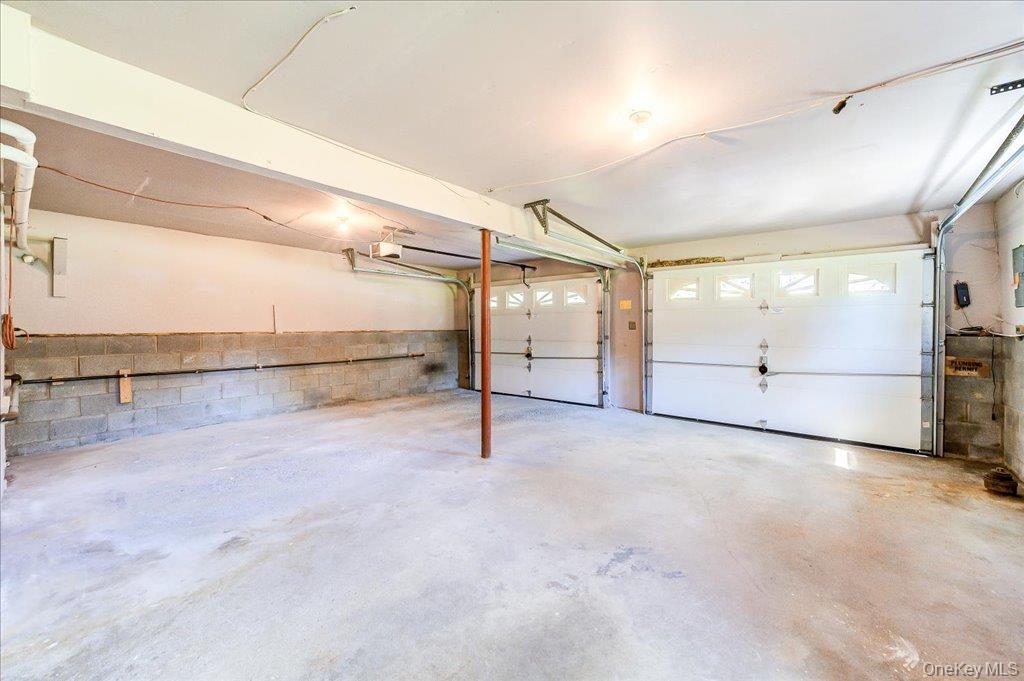 60 Sutton Park Road Poughkeepsie, NY 12603 - Photo 24 of 30 Two-car garage with concrete flooring and white panel doors