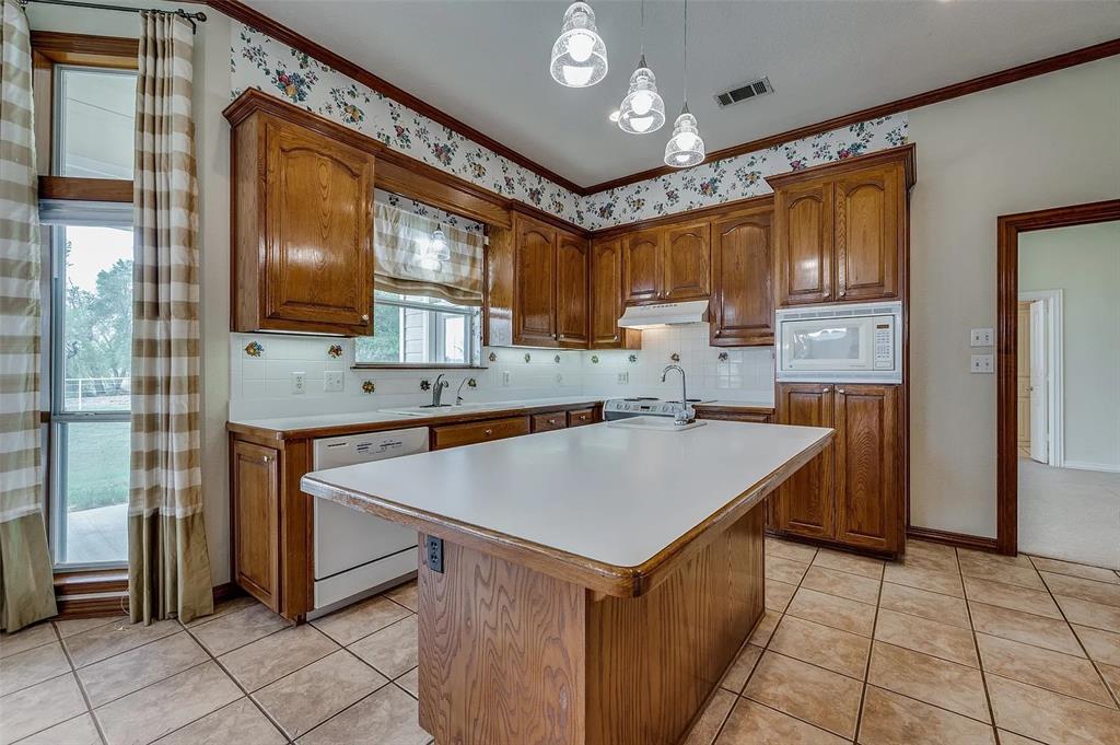 10200 Zipper Road Pilot Point, TX 76258 - Photo 4 of 18 a kitchen with a sink refrigerator and cabinets