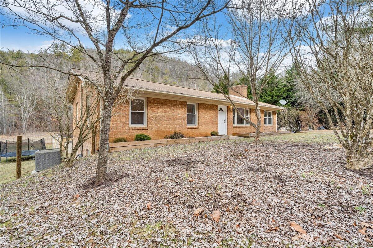 960 Sowers Road Northeast Floyd, VA 24091 - Photo 54 of 87 a backyard of a house with large trees and barbeque oven