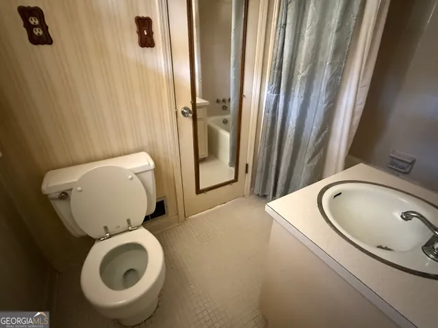 a bathroom with a toilet sink and mirror