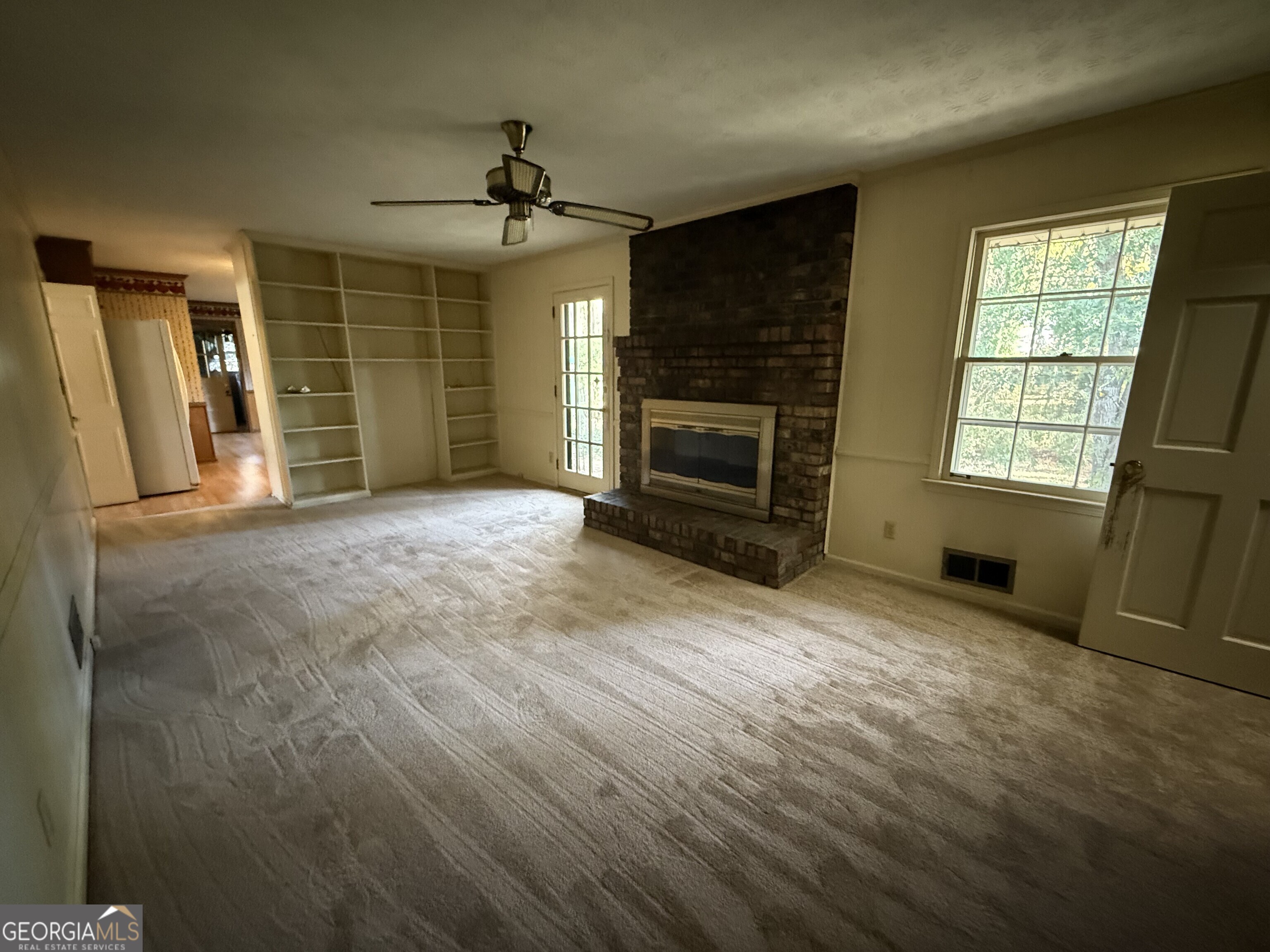 5904 Foxfield Trail Rex, GA 30273 - Photo 7 of 13 an empty room with windows fireplace and wooden floor