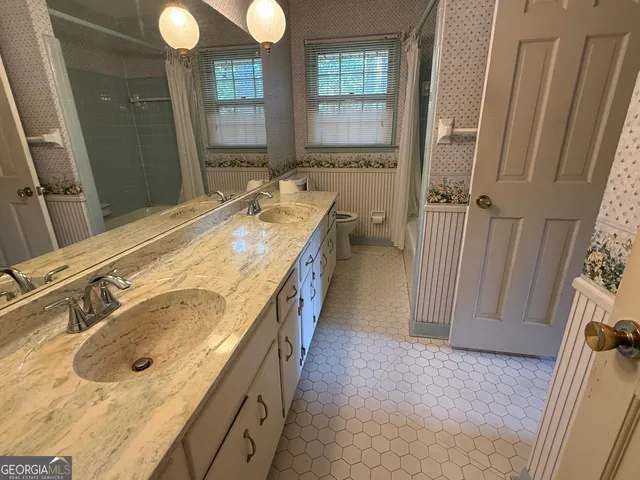 a spacious bathroom with a tub sink and mirror