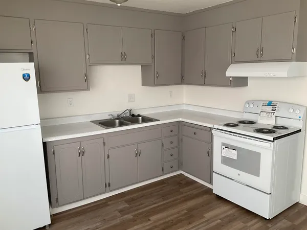 a kitchen with granite countertop white cabinets and white appliances