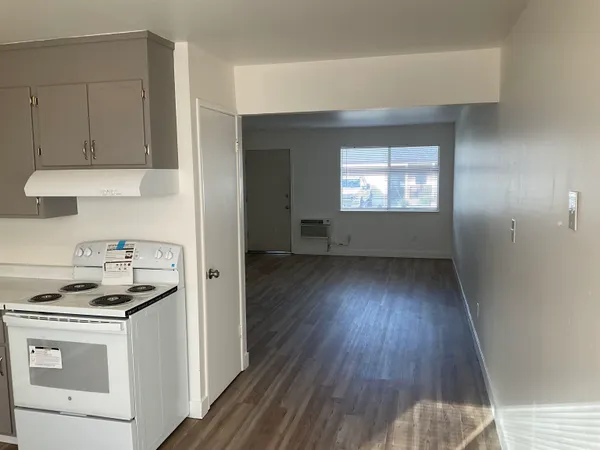 a kitchen with cabinets and wooden floor