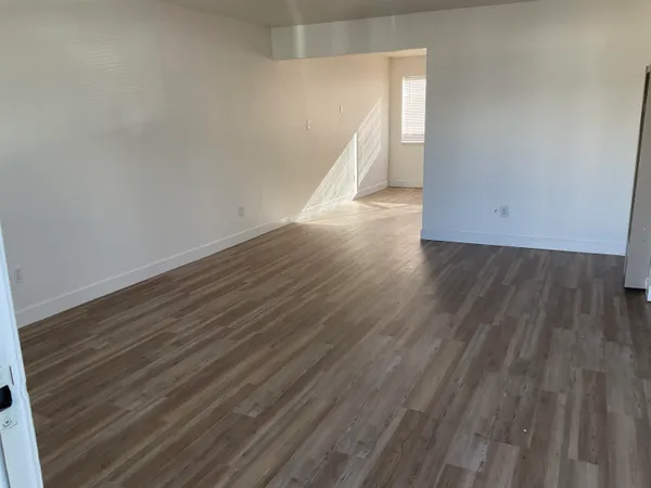 a view of an empty room with wooden floor