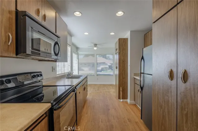 a kitchen with stainless steel appliances granite countertop a refrigerator a stove and a microwave with wooden floor