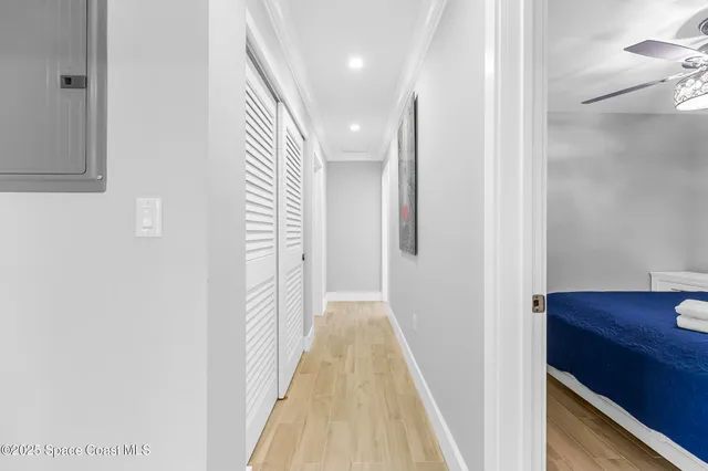 a view of a hallway with wooden floor and staircase