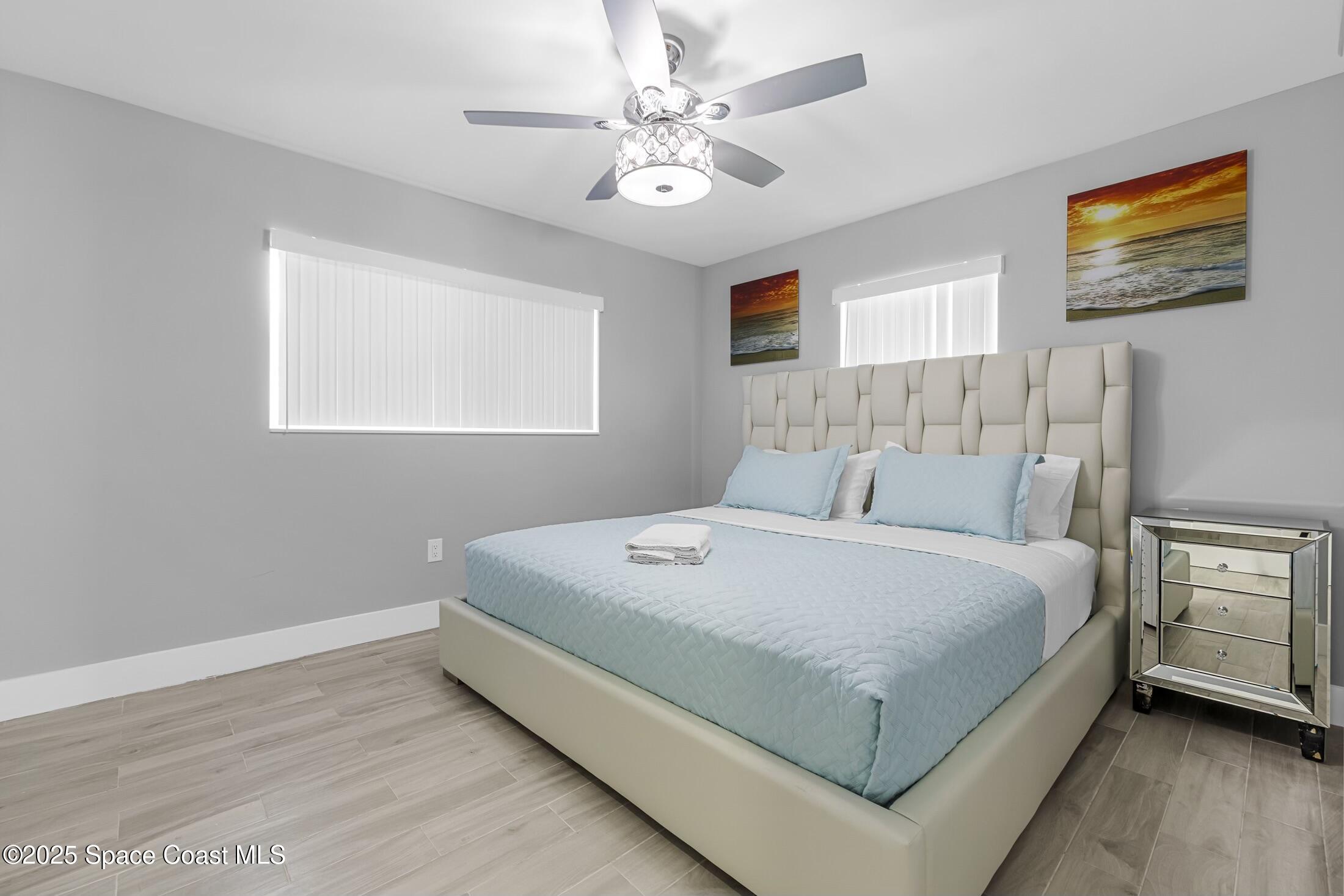 236 Northeast 3rd Street Satellite Beach, FL 32937 - Photo 17 of 22 a bedroom with a large bed and a chandelier