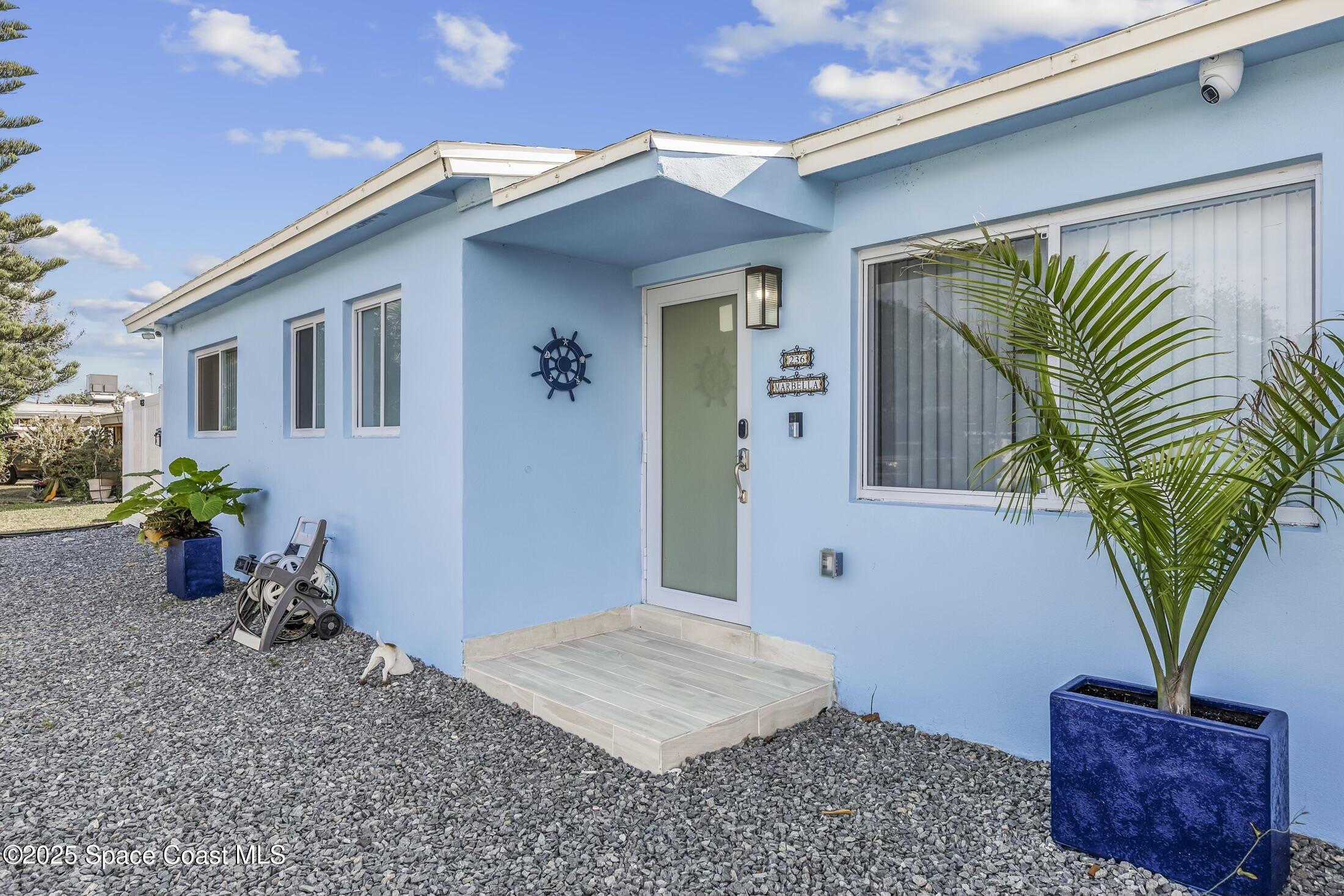 236 Northeast 3rd Street Satellite Beach, FL 32937 - Photo 2 of 22 a front view of a house with garden