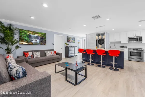 a living room with furniture and kitchen view
