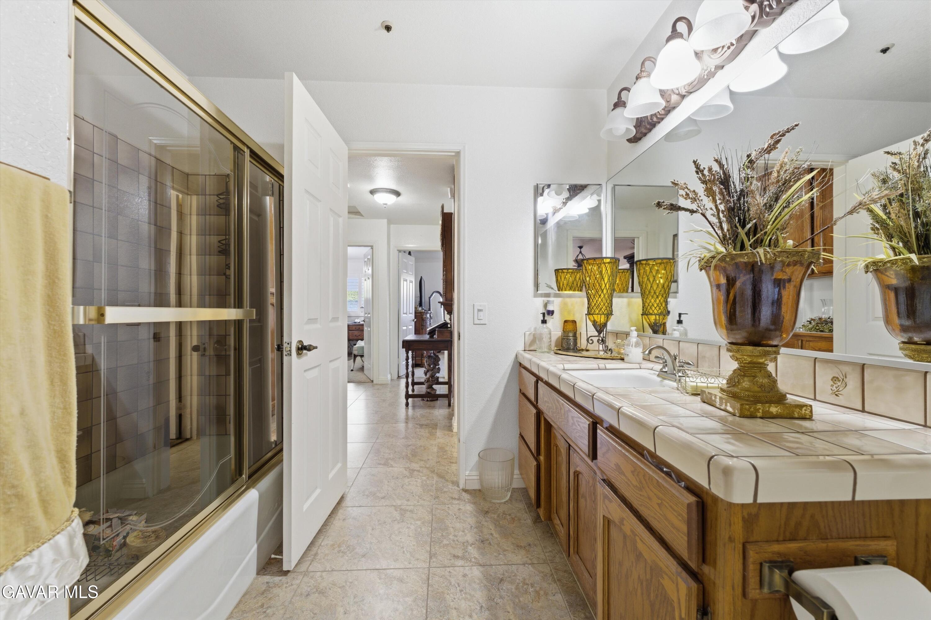 5801 Hacienda Ranch Road Palmdale, CA 93551 - Photo 27 of 69 a bathroom with a sink a mirror and a shower