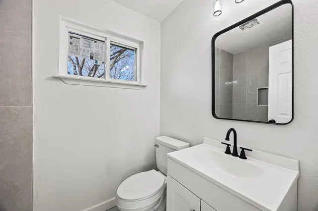 a bathroom with a toilet sink and mirror