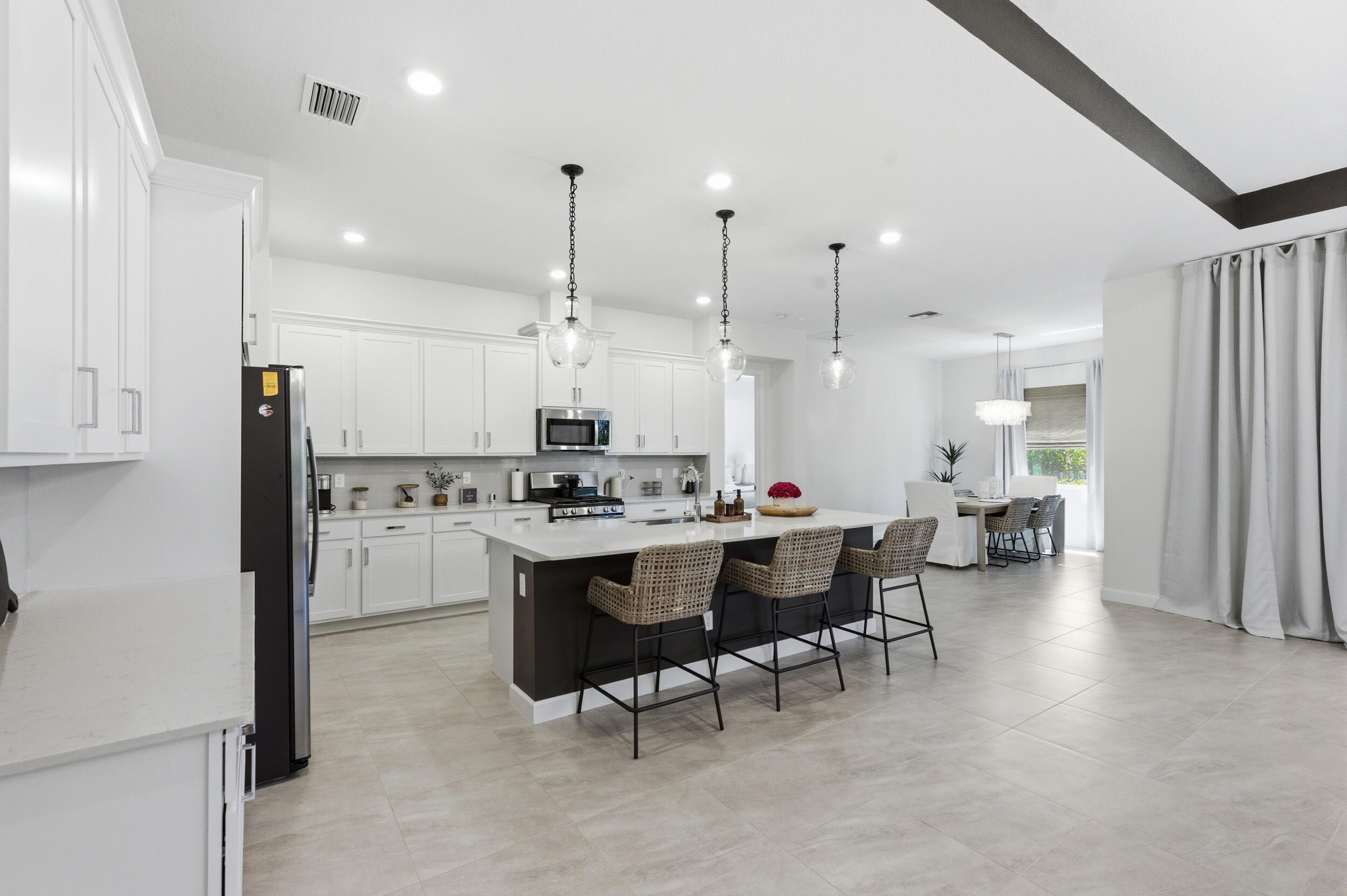 19230 Rolling Acres Road Loxahatchee, FL 33470 - Photo 34 of 58 a large kitchen with a table and chairs