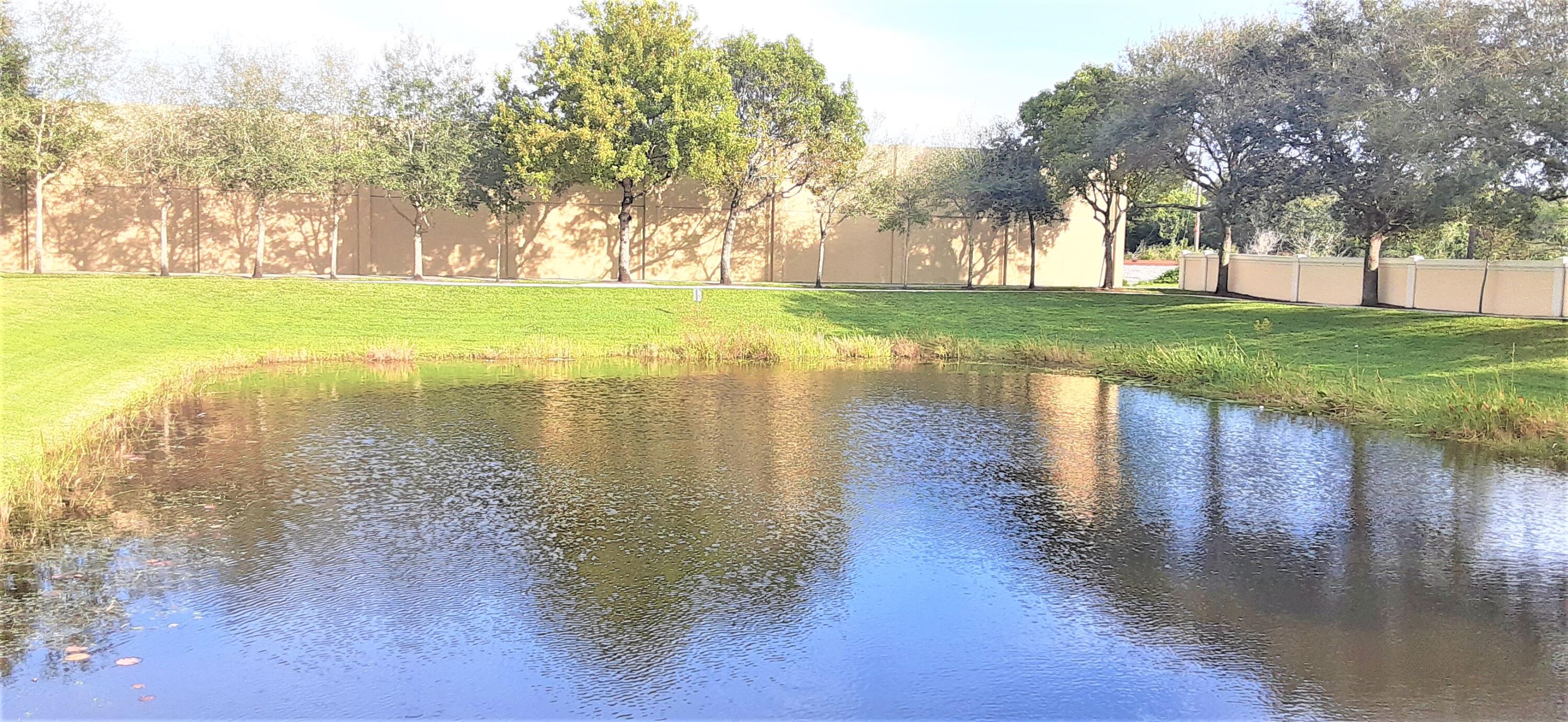 909 Northwest 18th Avenue Boca Raton, FL 33431 - Photo 37 of 39 a view of a lake with a yard and a large trees