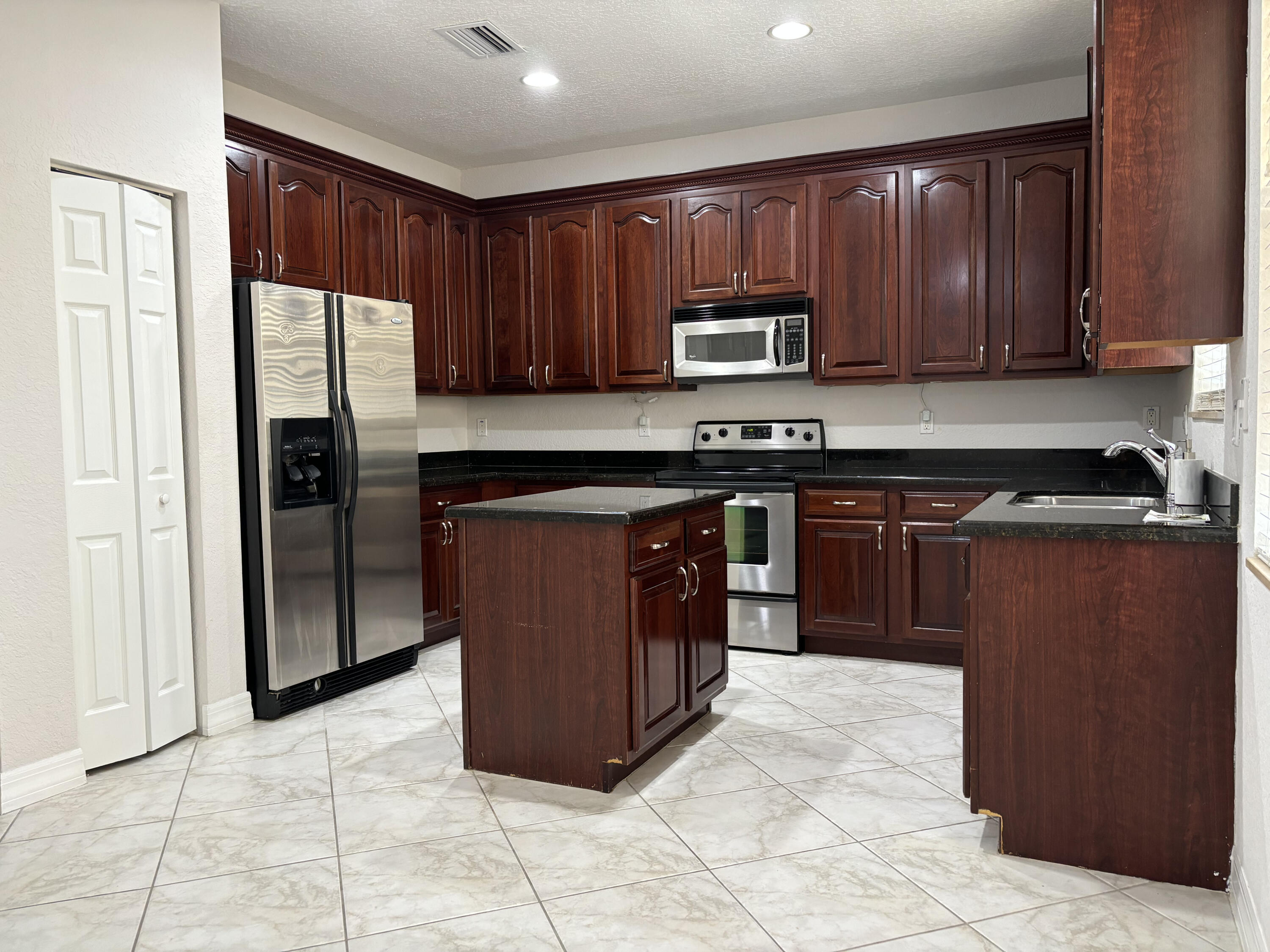 909 Northwest 18th Avenue Boca Raton, FL 33431 - Photo 7 of 39 a kitchen with stainless steel appliances granite countertop a stove a refrigerator and a sink