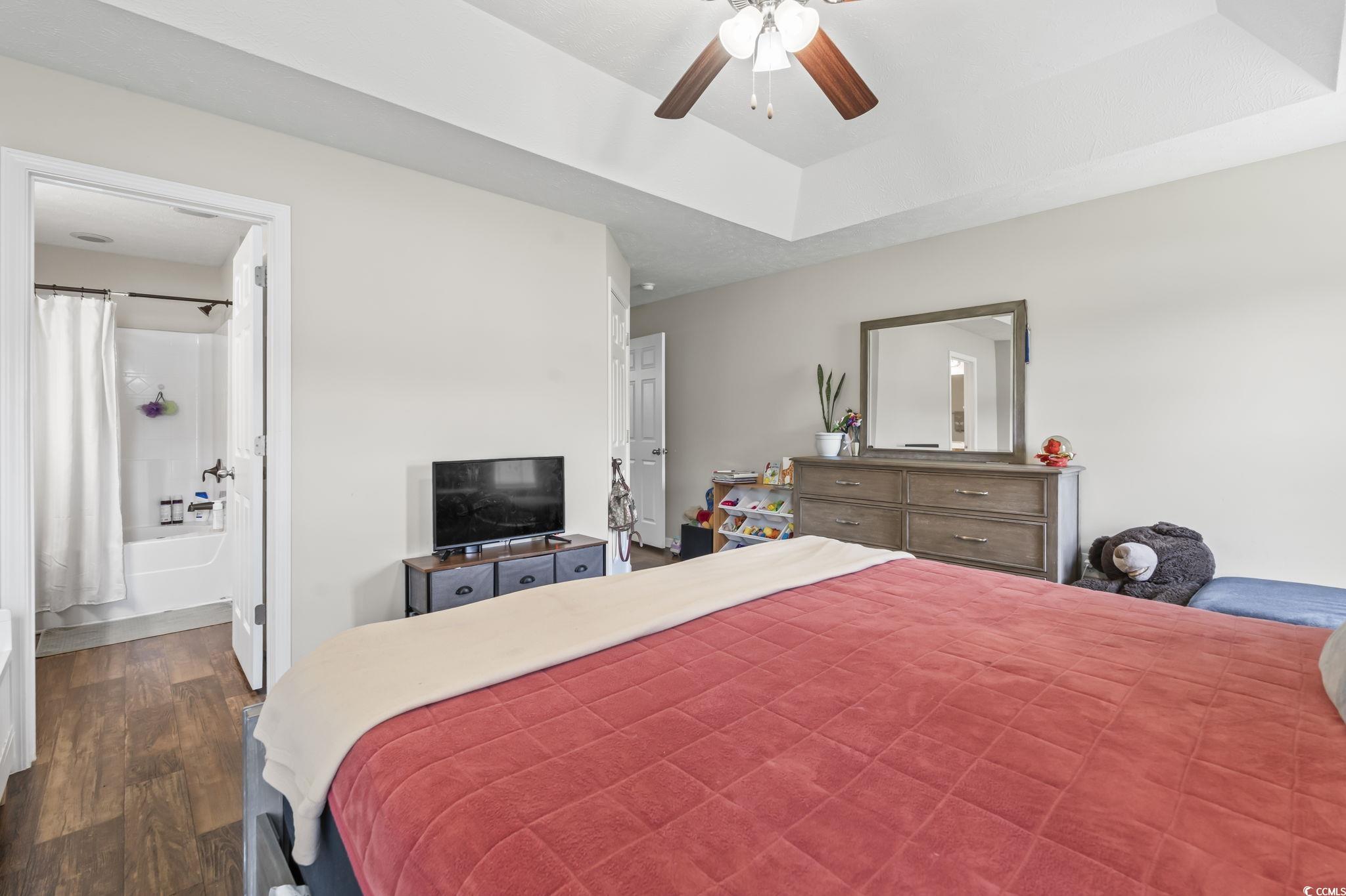 282 Foxpath Loop Myrtle Beach, SC 29588 - Photo 14 of 34 Bedroom featuring dark wood-type flooring, ensuite bath, and a ceiling fan