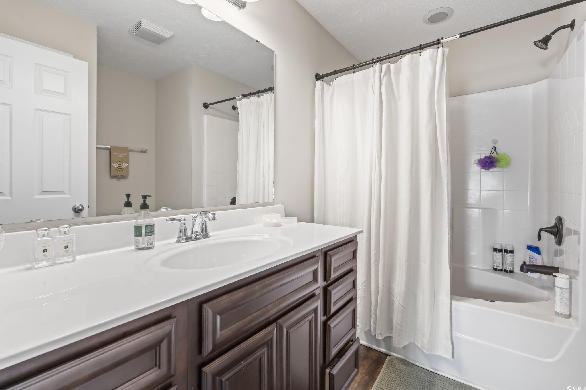 282 Foxpath Loop Myrtle Beach, SC 29588 - Photo 16 of 34 Bathroom with vanity, shower / tub combo, and wood finished floors