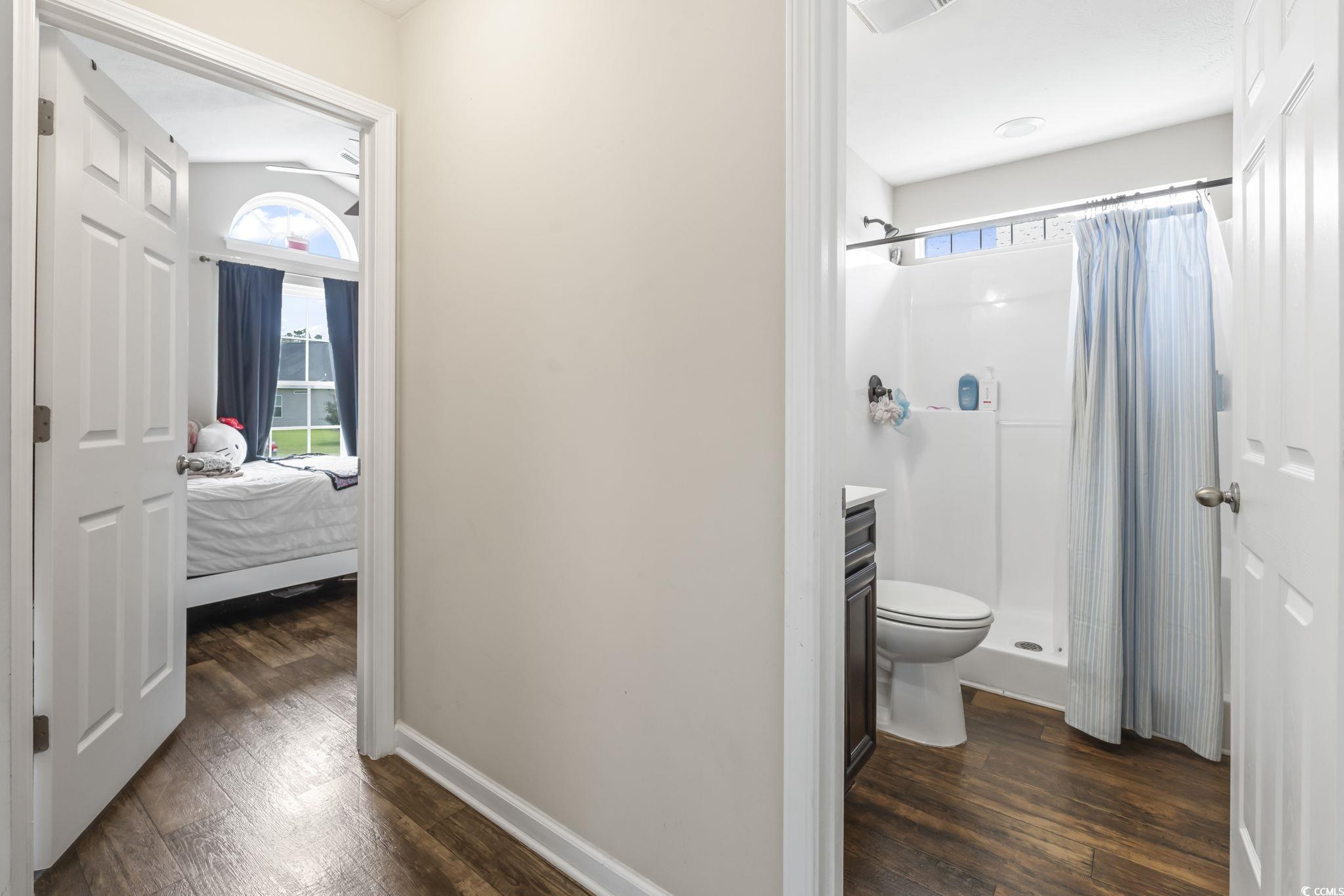 282 Foxpath Loop Myrtle Beach, SC 29588 - Photo 21 of 34 Bathroom with wood finished floors, a stall shower, toilet, baseboards, and ensuite bathroom