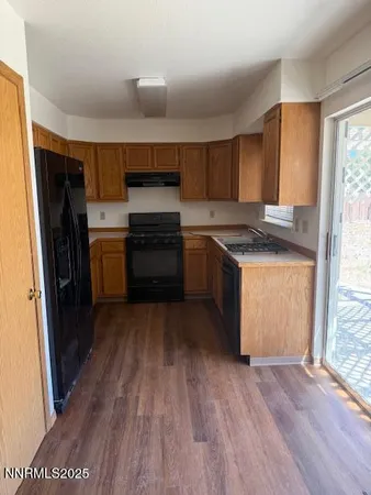 a kitchen with a sink wooden floor and stainless steel appliances