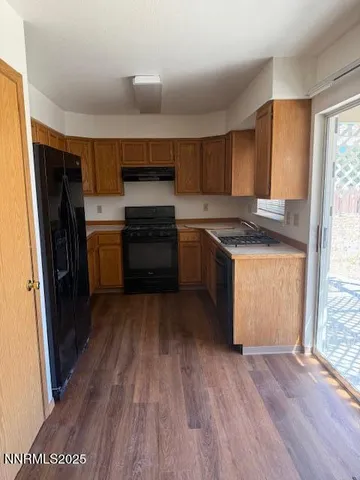 a kitchen with a sink wooden floor and stainless steel appliances