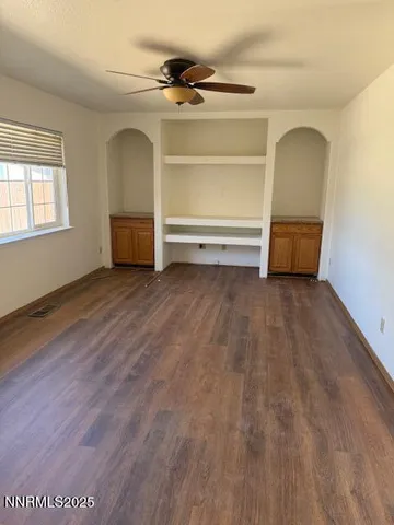 a view of a room with a furniture and a ceiling fan