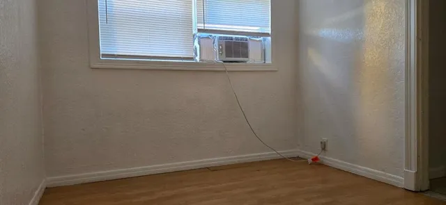 a view of a small space with wooden floor and a window